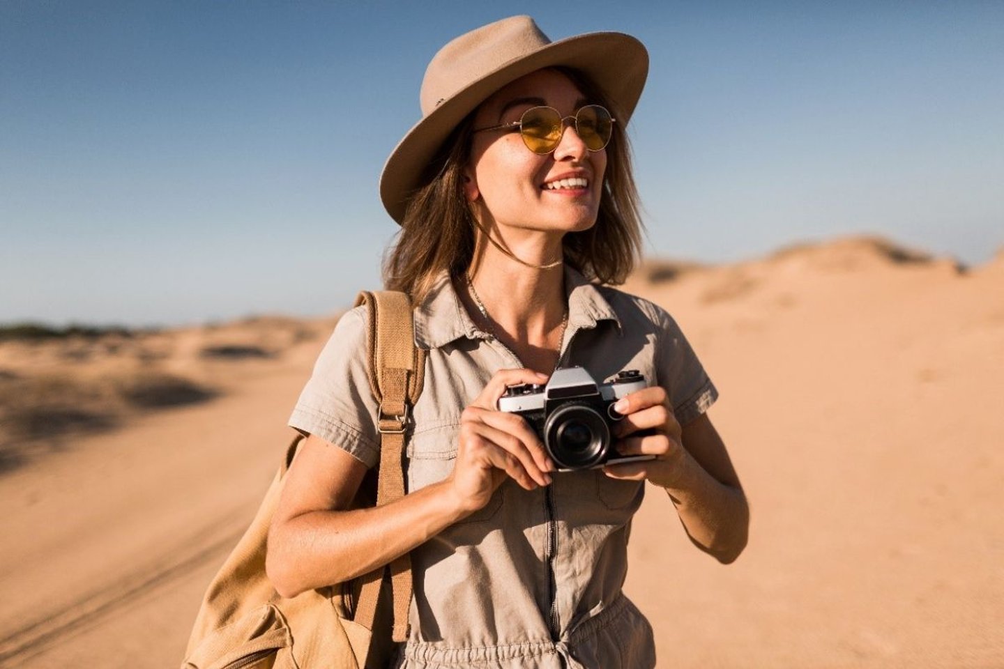 Girl with camera in desert